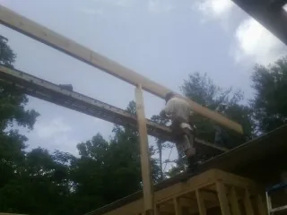 Carpenter setting a ridge beam over a new addition frame — Ice Dam Removal by Roofing Brothers in David City