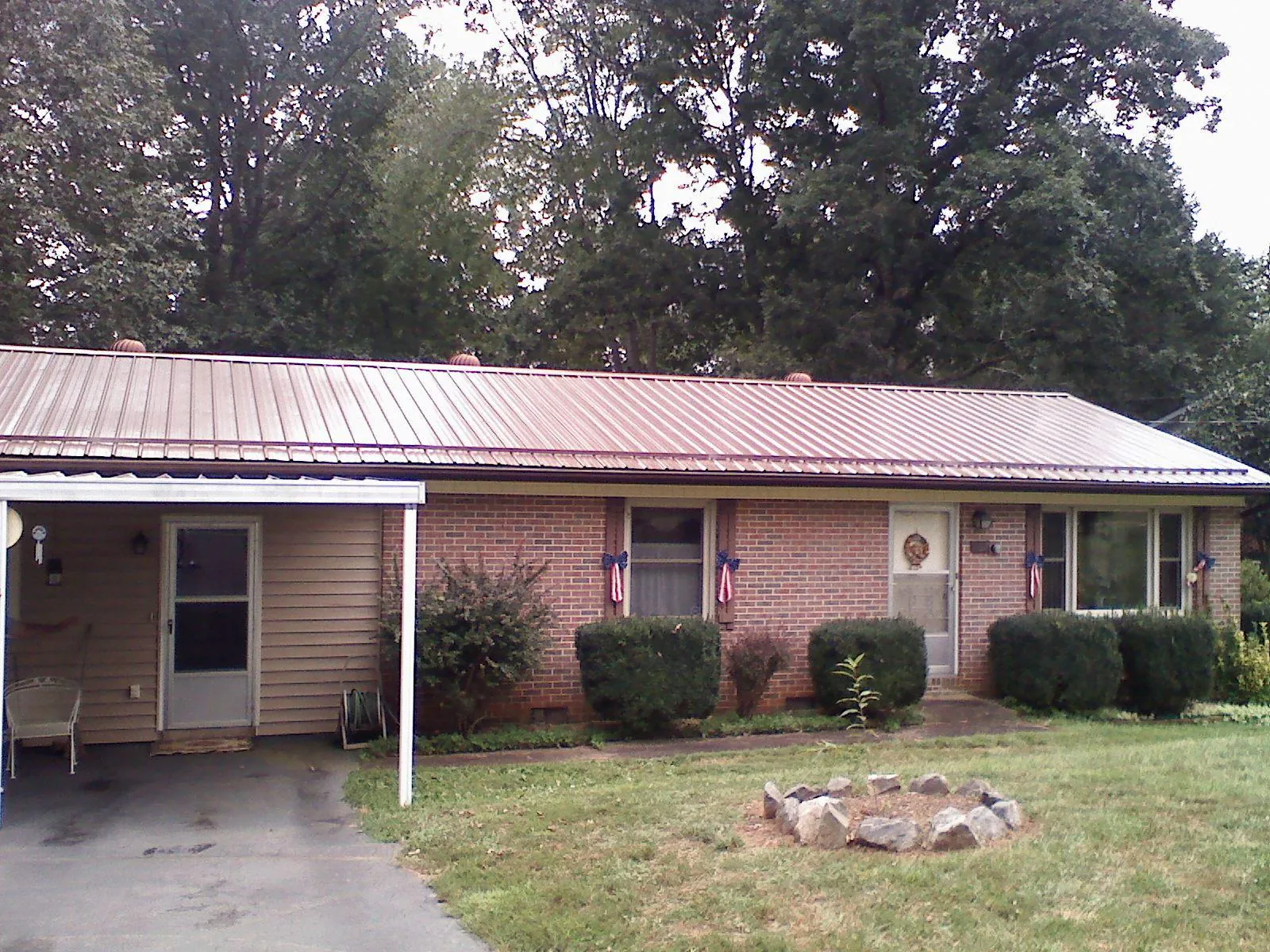 Bronze metal roof and carport on a brick ranch home — Roof Repair work by our crew in David City
